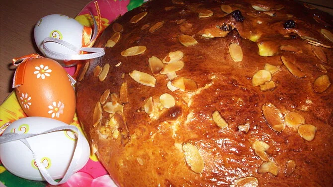 Zlatohnutý easter mazanec s mandlemi vedle vajíček.