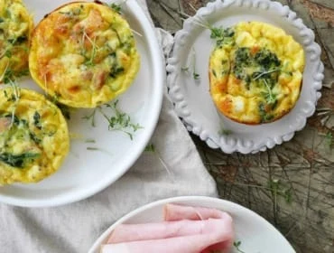 Pečené špenátové muffiny s vejci vedle kousků uzeného masa.
