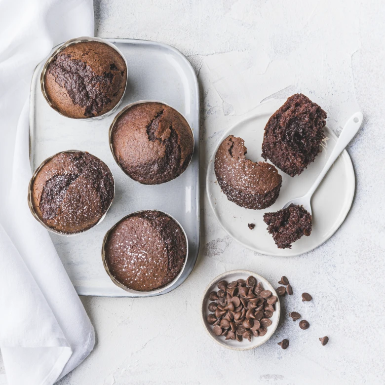 Čokoládové muffiny s čokoládovými kousky v plechovém podnosu.