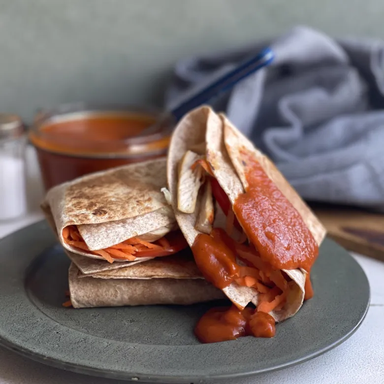 Plněná tortilla s omáčkou mrkví na talíři