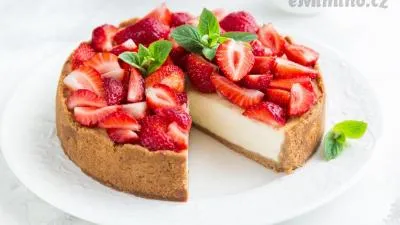 Kusový jahodový cheesecake s mascarpone na bílém talíři.