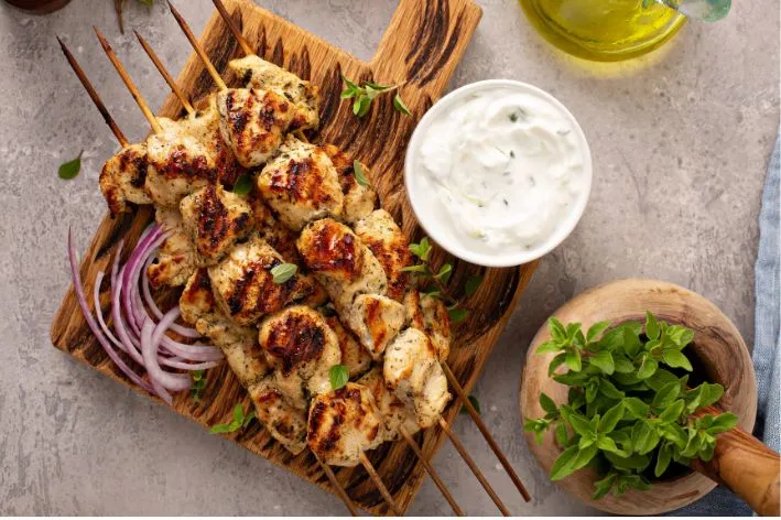 Pečené kuřecí souvlak na špejlech s dipem z jogurtu a čerstvými bylinkami.