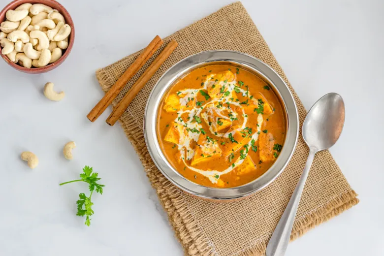 Vegetariánské kari s kakaem a skořicí na bílém podkladu.