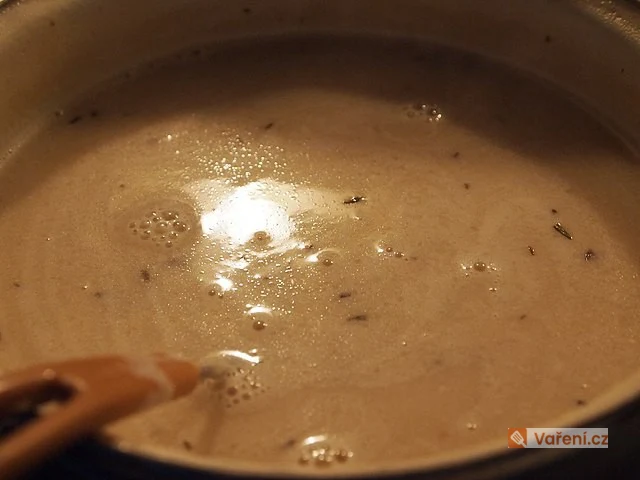Křemenná omáčka k masu se vaří v hrnci s dřevěnou lžící.