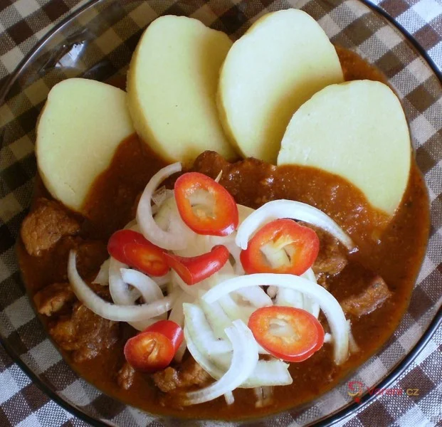 Hotová vepřový guláš s bramborami, cibulí a chilli papričkou.