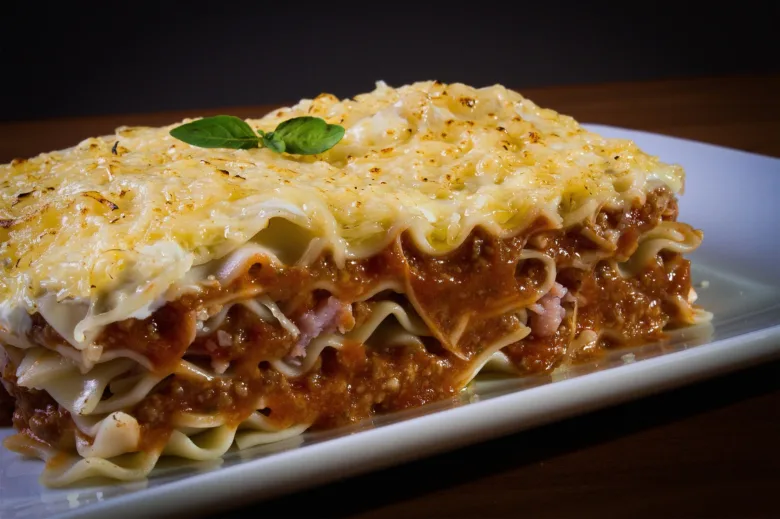Kousek italské boloňské lasagne s mletým masem a sýrem.