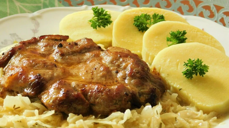 Připravená vepřová krkovice se zelím a bramborami.