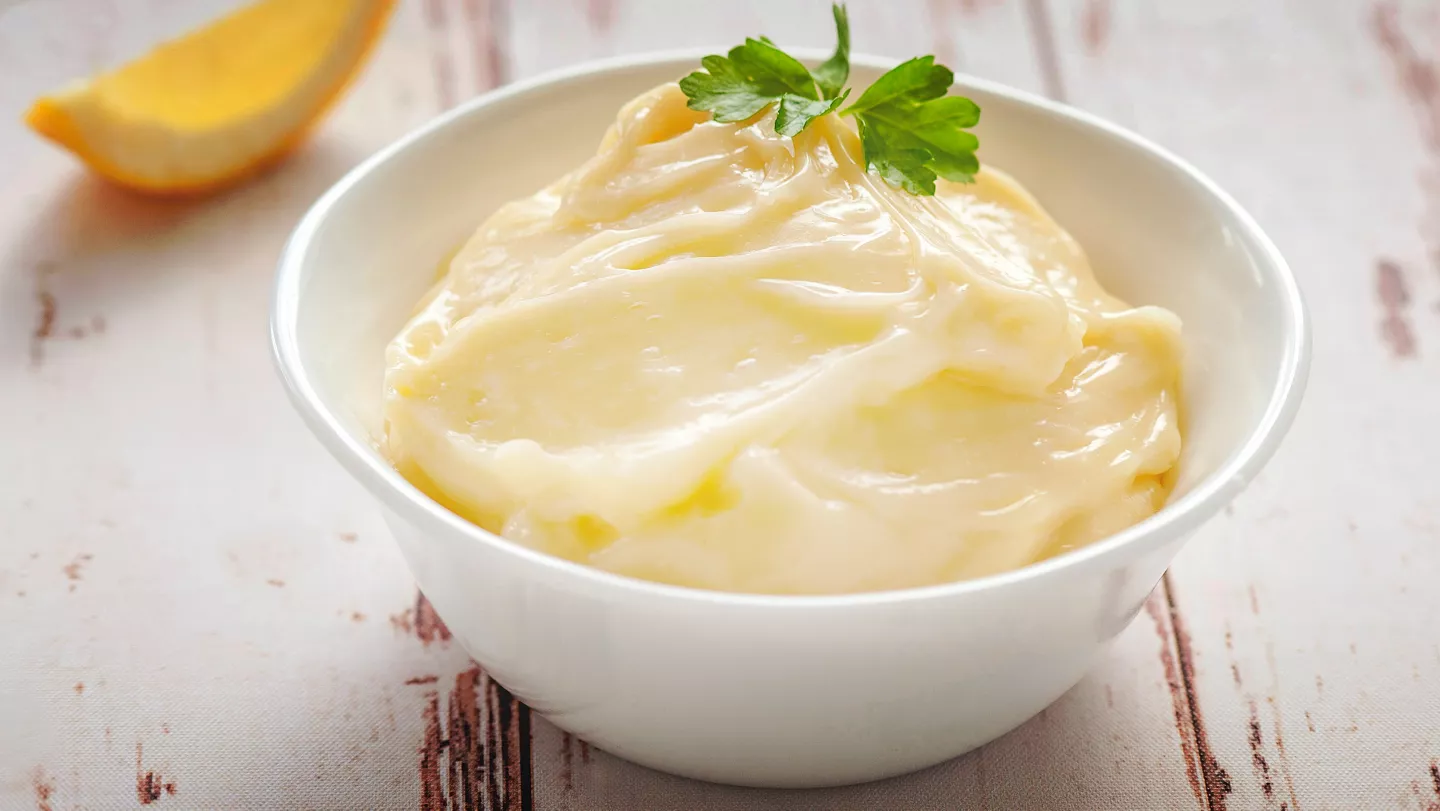 Bílá miska s domácí majonézou ozdobená petrželkou.