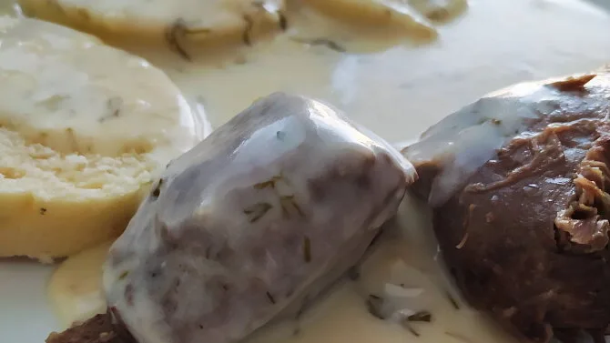 Uzené klobásy v koprové omáčce s rohlíky.