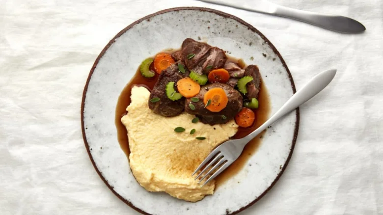 Polenta s masem v omáčce na talíři