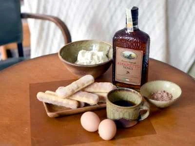 Ingredience pro italské tiramisu včetně likéru na stůl.