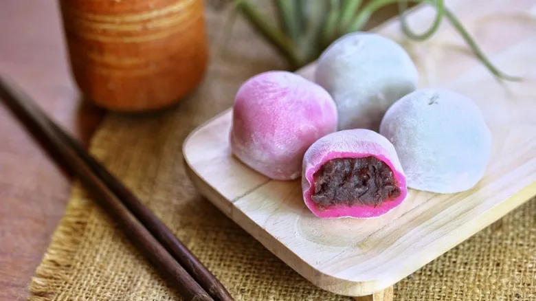 Japonské mochi koláčky s fialovou barvou a červenobílkovým náplní.
