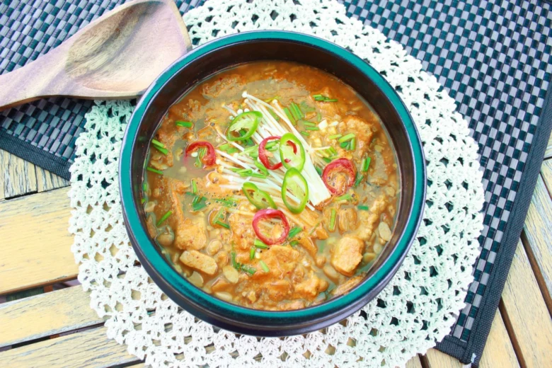 Veganská polévka s tofu a houbovými kousky v misce.
