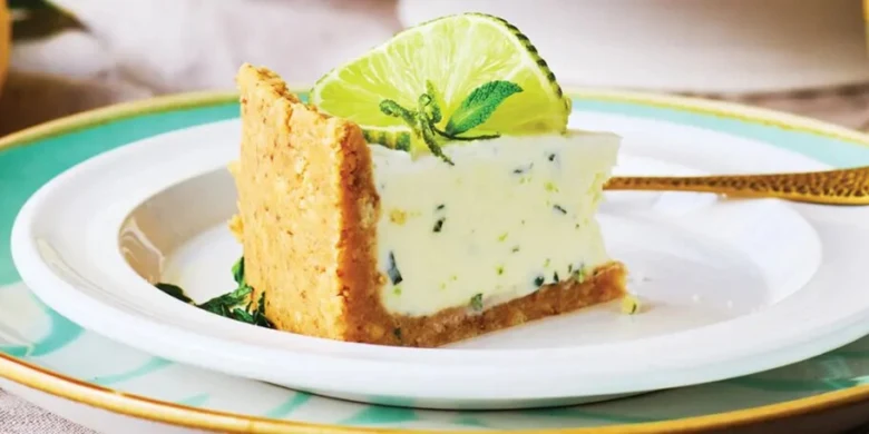 Kousek limetkového nepečeného cheesecaku s citronovou kůrou.