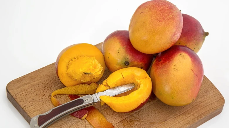 Mango na dřevěném prknu s odškrápnutou kůrou