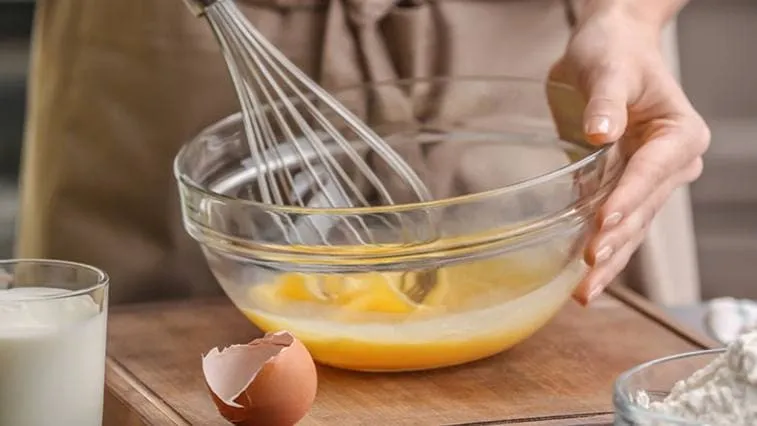 Lidé šlehaní vejce v míse na recept.