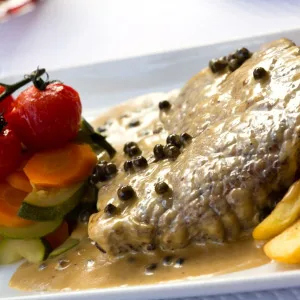 Steak s omáčkou z kaprů podaný se zeleninou.