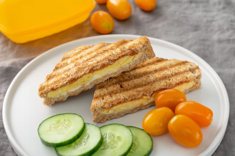 Zapečený toast s vejcem a sýrem na bílém talíři