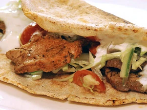 Hotový domácí gyros s masem, zeleninou a omáčkou.