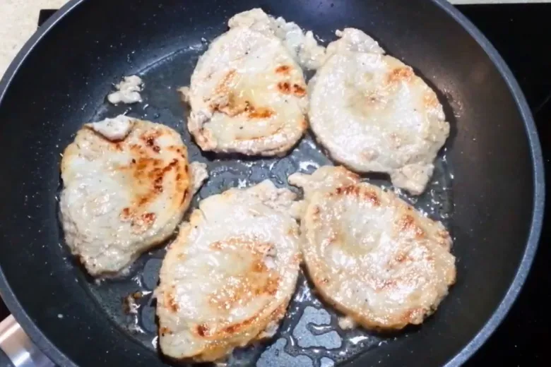 Pánev s smaženými kousky vepřového masa na pánvi.