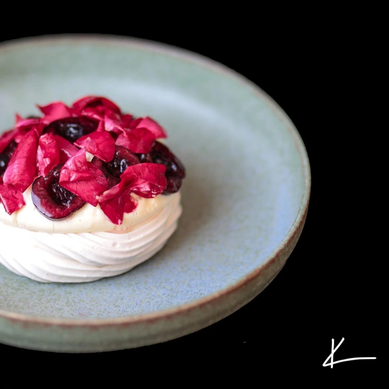 Hotová pavlova s ovocem na talíři jako výsledek receptu.