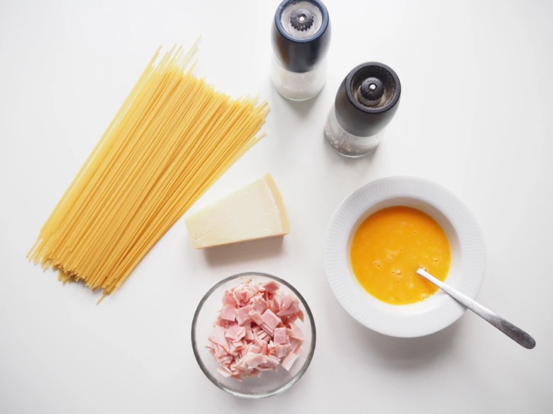 Ingredience pro špagety carbonara: těsto, sýr, uzenina, vejce.