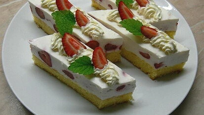 Kusky koláče s tvarohovou náplní, jahodami a smetanou.