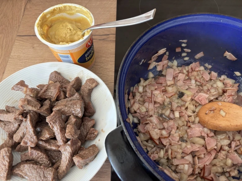 Připravované znojemské omáčky s masem a cibulí na pánvi.
