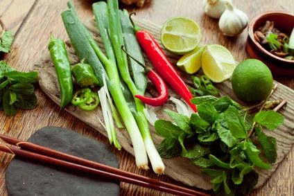 Svěží ingredience pro vietnamskou polévku pho na dřevěném prknu.