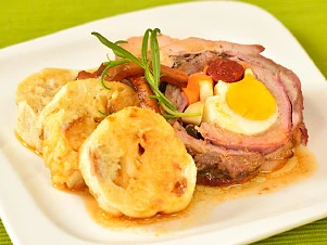 Hotová vepřová roláda s vejcem a smaženými bramborami.