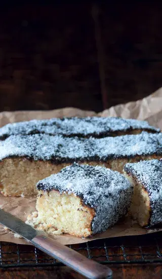 Kousíček kefírové buchty s kokosem posypaný moučkovým cukrem.
