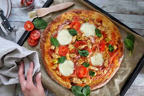 Domácí pizza na plechu s rajčaty, bazalkou a syrem