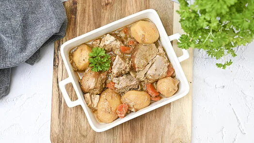 Pekoucí vepřové maso s bramborami a mrkví ve formě.