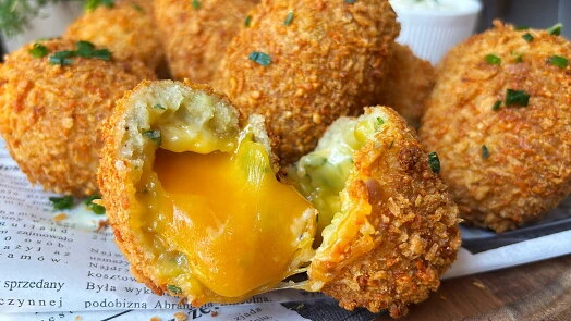 Zlatě hnědé bramborové krokety s taveným sýrem a vejcem uvnitř.