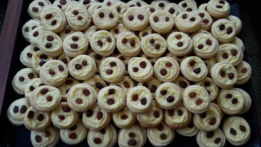Tray full of Czech cottage cheese rolls with raisin topping.
