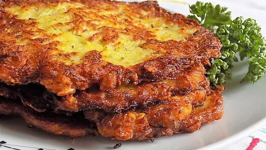 Skládané smaženky z brambor s petrželkou na talíři.