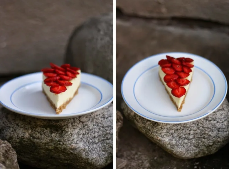 Kousek jahodového cheesecaku s čerstvými jahodami na talíři.