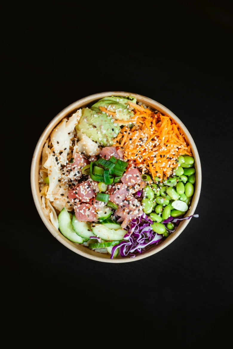 Poke bowl s tuňákem, avokádem a zeleninou v papírové mísce.