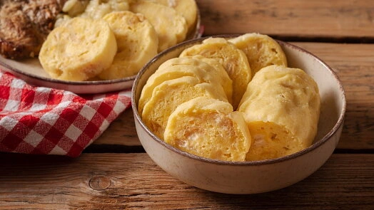 Kynuté houskové knedlíky nakrájené na plátky v misce.