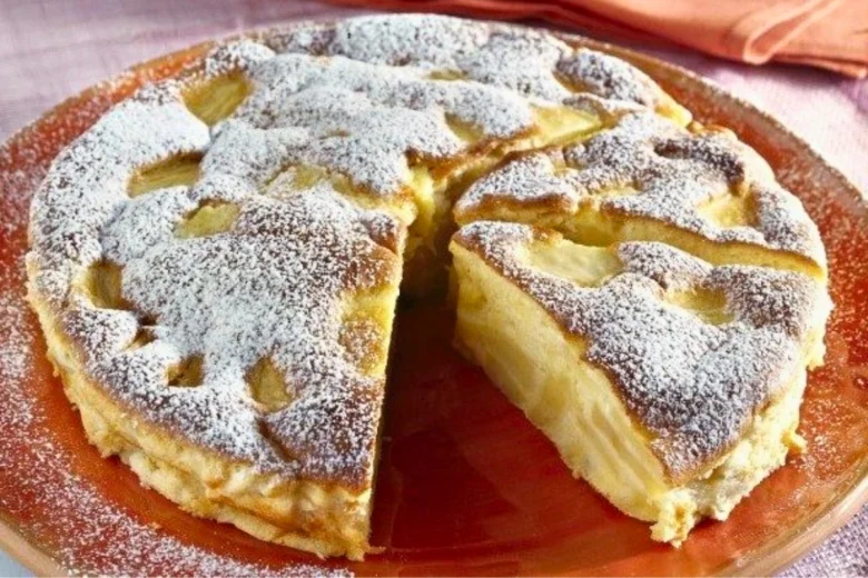 Jablečný koláč na plechu s moučkovým cukrem a vybranou kouskem.