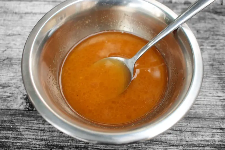 Orange sauce in bowl with spoon