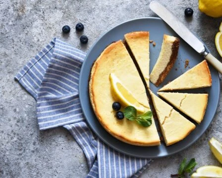 Sýrový koláč s ovocem a citronovou kůrou na talíři.