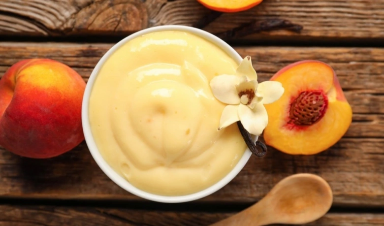 Vanilkový pudink s květem vanilky a nektarínem na dřevě.