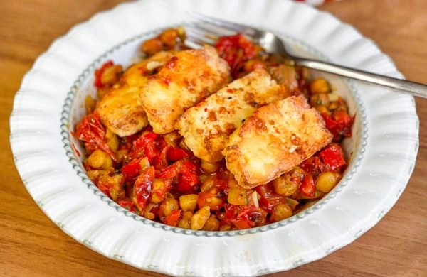 Grilovaný sýr halloumi pod pečenými rajčaty a cicerem.