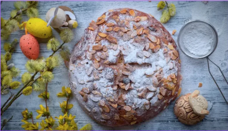 Tradiční easter vdolka s mandlemi a cukrem na bílém pozadí.
