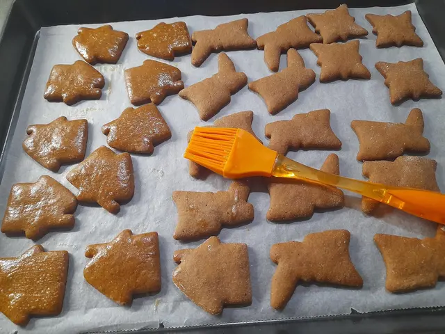 Vánoční perníčky tvarované jako zvířata na plechu před pečením.