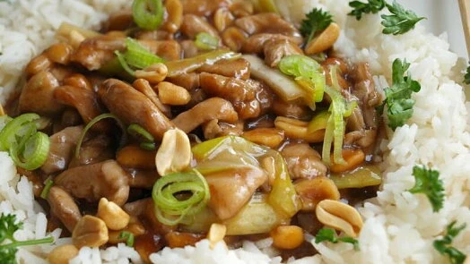 Kung Pao kuřecí maso s arašidy a zelenou cibulkou na rýži.
