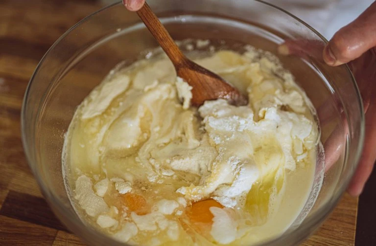 Směšování surovin pro hrníčkovou třešňovou bublaninu v míse.