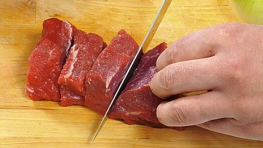 Rozkroj surového masa na proužky pro guláš.