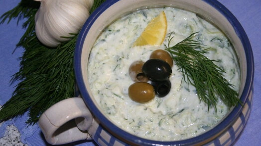 Miska s tzazikim ozdobená olivami, koprem a citronem.